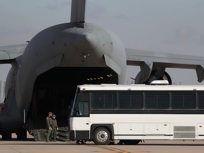 Una aeronave militar espera a migrantes que abordan un autobús en Fort Bliss, El Paso, Texas, el jueves 30 de enero de 2025.